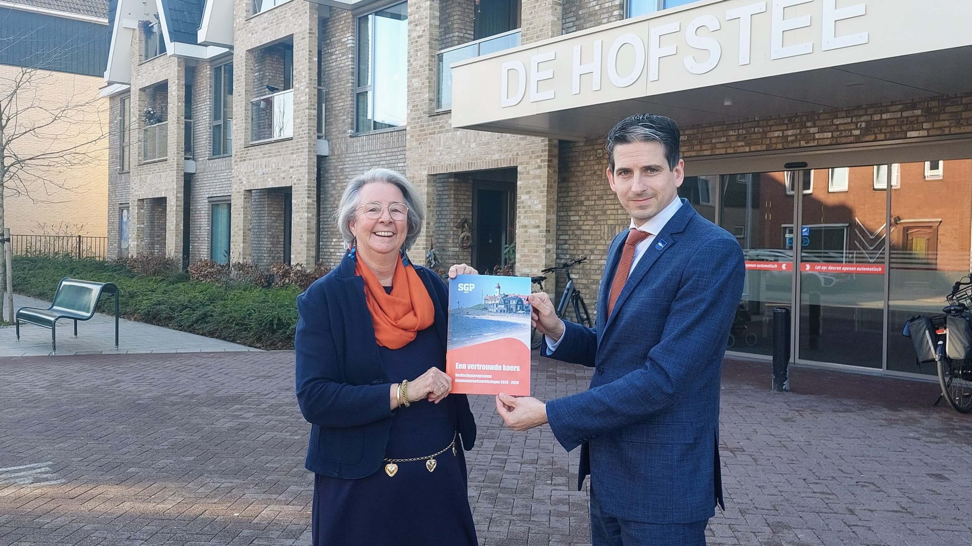 Co van den Heuvel ontvangt het eerste exemplaar van het verkiezingsprogramma uit handen van Tunis Hoekstra, lijsttrekker van de SGP